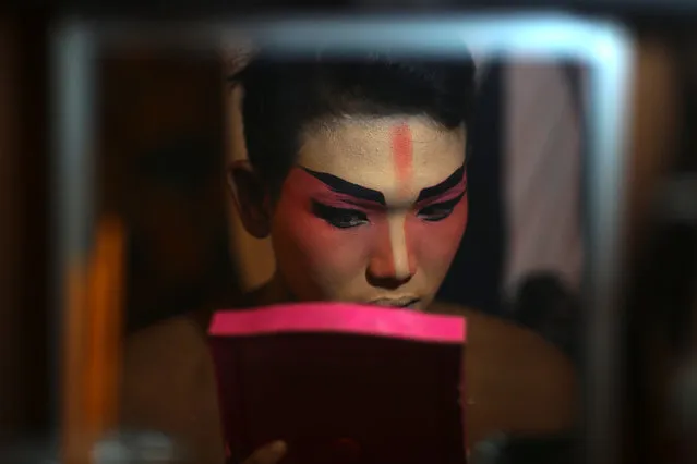 A member of a Chinese opera troupe applies make-up before performing at a shrine during the annual vegetarian festival in Bangkok, Thailand, October 4, 2016. (Photo by Athit Perawongmetha/Reuters)
