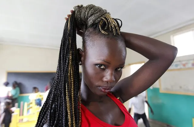 A model prepares at a makeshift venue backstage before the Miss Koch beauty pageant, titled “Getting to Zero Teenage Pregnancy”, at the Korogocho slums in Nairobi, December 6, 2014. (Photo by Thomas Mukoya/Reuters)