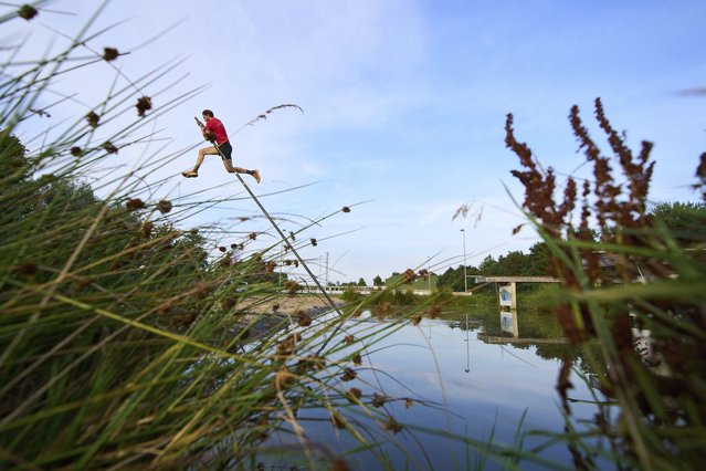 An athlete practices jumping across a body of water during a Fierljeppen competition in Kockengen, Netherlands, Wednesday, August 27, 2025. (Photo by Peter Dejong/AP Photo)