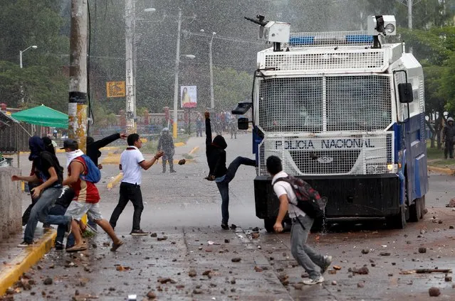 Students attack a National Police water cannon vehicle during a protest to demand the resignation of Honduran President Juan Orlando Hernandez in Tegucigalpa, Honduras, November 4, 2015. The protesters are calling the United Nations to intervene and establish an anti-impunity commission, similar to the CICIG in neighboring Guatemala. (Photo by Jorge Cabrera/Reuters)