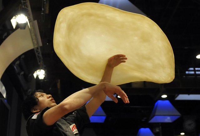 Takumi Tachikawa, of Japan, performs with his dough during the freestyle event, part of the Pizza World Championships, in Parma, northern Italy, Wednesday, April 17, 2013. (Photo by Marco Vasini/AP Photo)