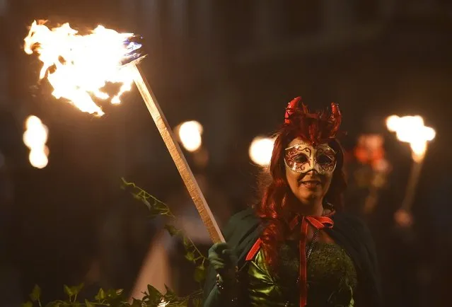 Participants in costume hold burning torches as they take part in one of a series of processions during Bonfire night celebrations in Lewes, southern England, November 5, 2015. (Photo by Toby Melville/Reuters)