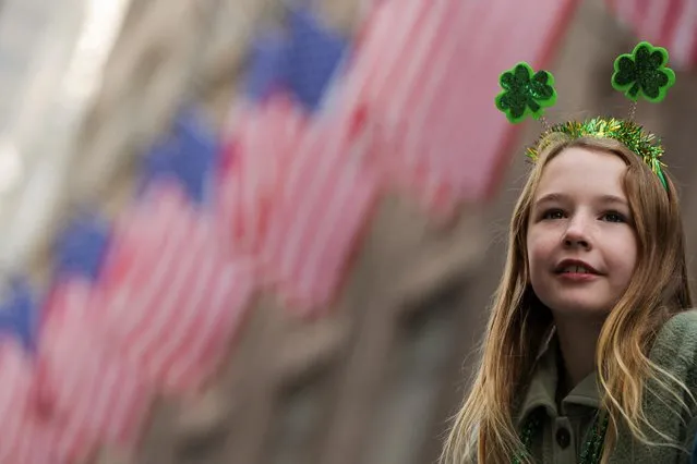 A girl watches the annual Saint Patrick's Day parade on 5th Avenue in Manhattan in New York City, New York, U.S., March 17, 2023. (Photo by Andrew Kelly/Reuters)