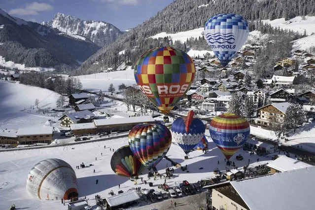 Hot air balloons take off during the 43th International Hot Air Balloon week, in the skiing resort of Chateau-d'Oex, in the Swiss Alps, Saturday, January 21, 2023. Postponed twice because of the pandemic, The International Hot Air Balloon Festival of Chateau-d'Oex (VD) returns this year for a 43rd edition. 60 balloons from 15 countries will be taking part in the event between the 21th and the 29nth of January in the Swiss mountain resort is famous for ideal flight conditions due to an exceptional microclimate. (Photo by Anthony Anex/Keystone via AP Photo)
