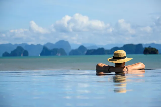 A tourist enjoys the view of the Hong islands from the infinity pool of a resort on Koh Yao Yai island, Thailand in the Andaman Sea on November 23, 2020. (Photo by Mladen Antonov/AFP Photo)