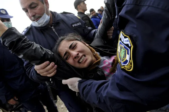 Greek policemen carry away a woman as Syrian, Iraqi and Afghan refugees who try to force their way through the Greek-Macedonian borders are pushed back by Greek police, near the village of Idomeni, Greece November 22, 2015. (Photo by Alexandros Avramidis/Reuters)