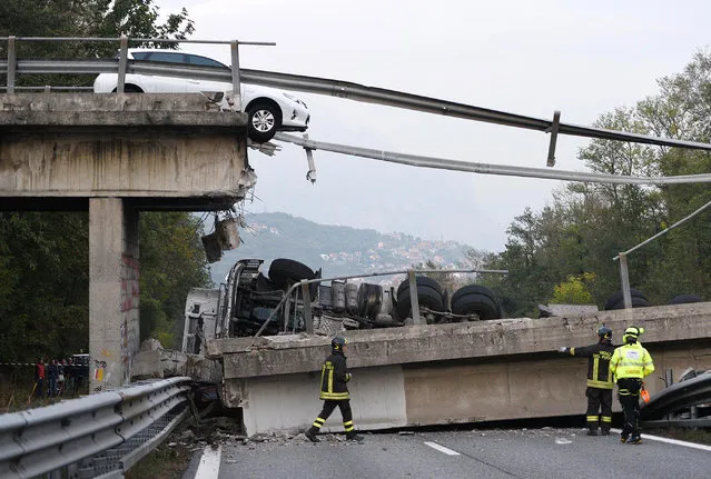 A car is stopped just where an overpass collapsed when a heavy truck, seen on the road below, was traveling on it, between Milan and Lecco, northern Italy, Friday, October 28, 2016. An overpass north of Milan has collapsed under the weight of a truck carrying an over-size load just hours after highway authorities say they requested the road’s immediate closure. (Photo by Fabrizio Cusa/ANSA via AP Photo)