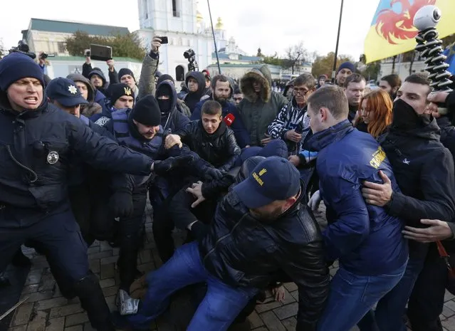Ukrainian police officers hold back nationalists who are trying to prevent a rally in support of cannabis decriminalization in downtown Kiev, Ukraine, Saturday, October 29, 2016. A group of protesters tried to hold a rally to demand marijuana be no long classified as a hard drug. (Photo by Sergei Chuzavkov/AP Photo)