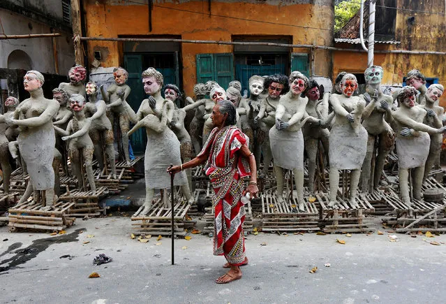 A woman walks past semi-finished clay idols of the Hindu mythological characters “Dakinis” and “Yoginis”, who will be worshipped along with the Hindu goddess Kali, at a roadside workshop ahead of the Kali Puja festival in Kolkata, India October 24, 2016. (Photo by Rupak De Chowdhuri/Reuters)