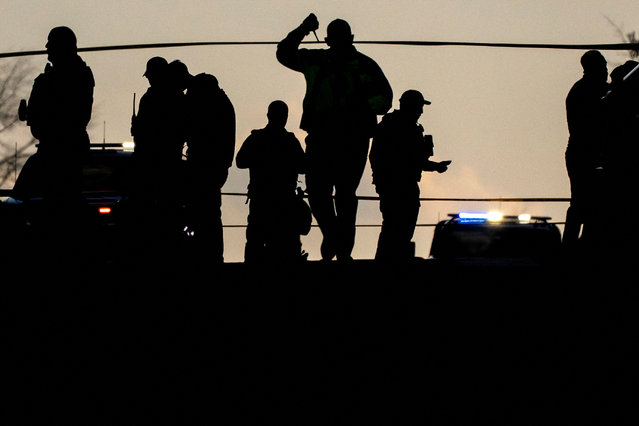 Law enforcement members are silhouetted as they gather in a cordoned-off area after two National Guard members were reportedly shot near the White House in Washington, D.C., U.S., November 26, 2025. (Photo by Nathan Howard/Reuters)