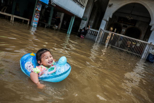 Duha, 2, plays on a flooded road near Tha-It mosque on the banks of the Chao Phraya River after increased discharge from the Chao Phraya Dam, in Nonthaburi province on the outskirts of Bangkok, Thailand, on November 14, 2025. (Photo by Chalinee Thirasupa/Reuters)