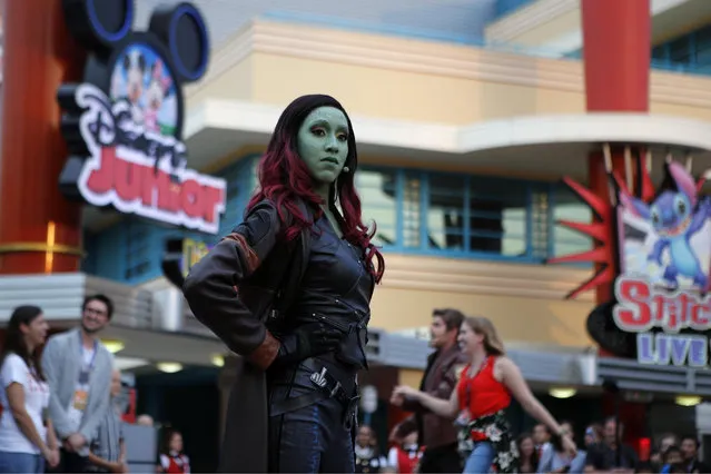 “Gamora” character of the “Guardians of the Galaxy” performs with the guests during the opening show at Disneyland Paris, Saturday, June 8, 2018. Helicopters, concept cars and swat teams shrouded in smoke heralded the launch of the first Avengers-themed season at Disneyland Paris following the announcement of a $2.5 billion expansion plan for the park, which will feature Marvel superheroes. (Photo by Francois Mori/AP Photo)