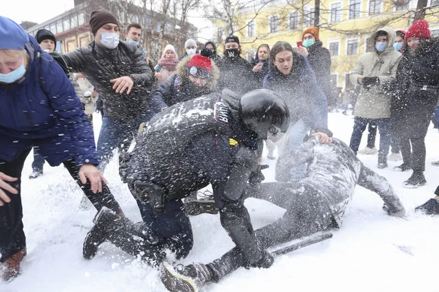 A policeman detains a man while protesters try to help him, during a protest against the jailing of opposition leader Alexei Navalny in St. Petersburg, Russia, Sunday, January 31, 2021. Thousands of people have taken to the streets across Russia to demand the release of jailed opposition leader Alexei Navalny, keeping up the wave of nationwide protests that have rattled the Kremlin. Hundreds have been detained by police. (Photo by Valentin Egorshin/AP Photo)