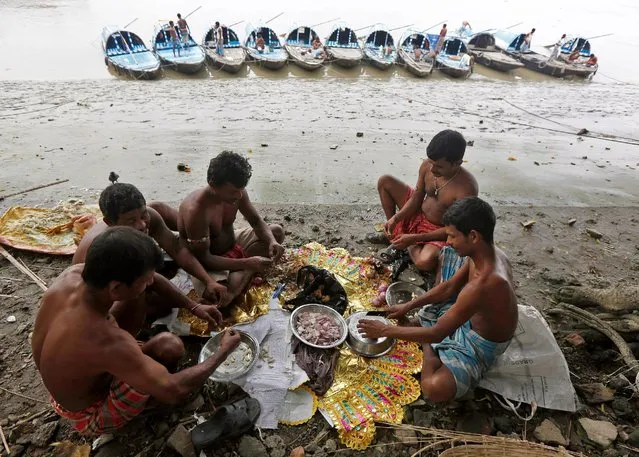 Workers chop vegetables before preparing their meal on the banks of the river Ganga in Kolkata, India, November 1, 2016. (Photo by Rupak De Chowdhuri/Reuters)