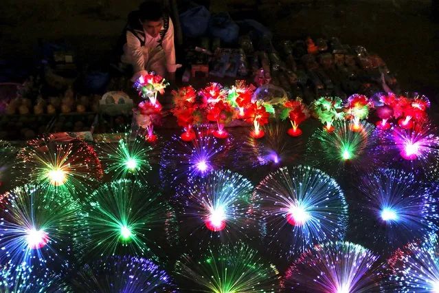 A man sells colorful lights at his stall in the market in Peshawar, Pakistan December 4, 2015. (Photo by Khuram Parvez/Reuters)
