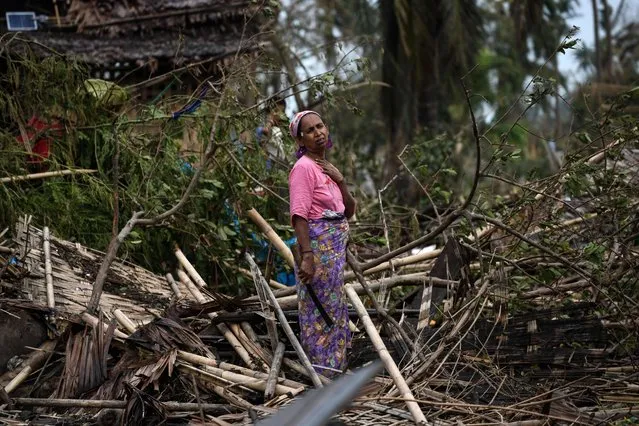 A Rohingya woman stands on her destroyed house at Basara refugee camp in Sittwe on May 16, 2023, after cyclone Mocha made a landfall. (Photo by Sai Aung Main/AFP Photo)