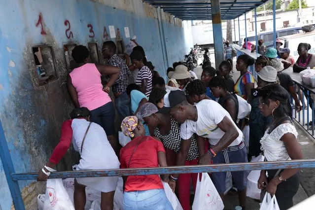 People gather outside the National Penitentiary for their turn to deliver food to their jailed relatives in downtown Port-au-Prince, Haiti, Thursday, June 1, 2023. In December 2022, the University of Florida published a study that found that men in Haiti’s prisons were on a starvation-level diet, consuming fewer than 500 calories a day. (Photo by Joseph Odelyn/AP Photo)