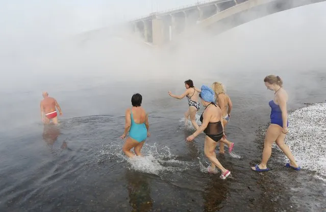 Women follow Mikhail Sashko (L), chairman and one of the founders of the Cryophile winter swimmers club, during a celebration of his 68th birthday in the Yenisei River in the Siberian city of Krasnoyarsk, Russia, November 21, 2015. “The moment of immersion is a sensation of delight. Afterwards there's a rush of energy and my entire body feels relaxed”�, says Sashko, a director in the construction industry. The air temperature was about minus 27 degrees Celsius. (Photo by Ilya Naymushin/Reuters)