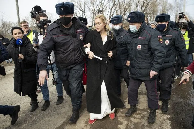 Police officers detain the Alliance of Doctors union's leader Anastasia Vasilyeva at the prison colony IK-2, which stands out among Russian penitentiary facilities for its particularly strict regime, in Pokrov in the Vladimir region, 85 kilometers (53 miles) east of Moscow, Russia, Tuesday, April 6, 2021. Doctors from the Navalny-backed Alliance of Doctors announced going to the Pokrov prison on Tuesday to demand the opposition leader gets qualified medical help from independent doctors after he complained about pain in his leg and back. (Photo by Pavel Golovkin/AP Photo)