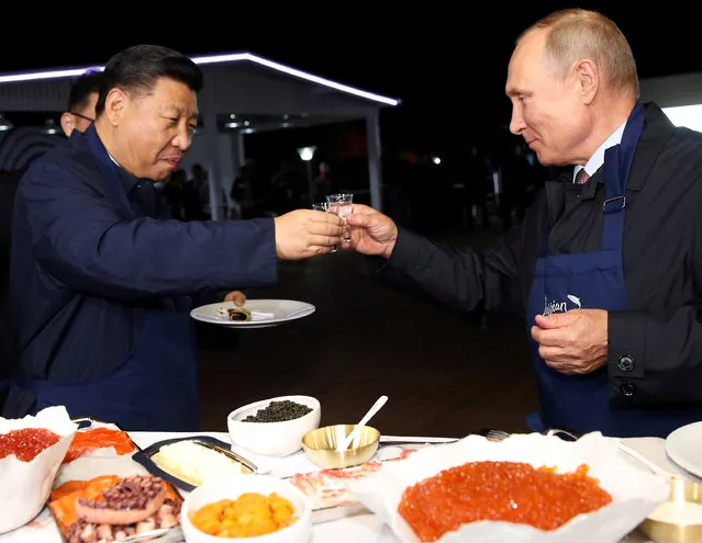Russian President Vladimir Putin and Chinese President Xi Jinping toast during a visit to the Far East Street exhibition on the sidelines of the Eastern Economic Forum in Vladivostok, Russia on September 11, 2018. (Photo by Sergei Bobylev/TASS Host Photo Agency/Pool via Reuters)
