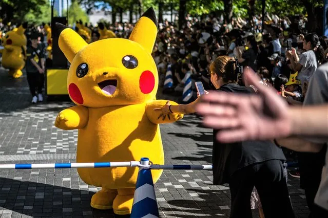 People watch the Pikachu parade which is a part of the 2023 Pokémon World Championships, at Grand Mall Park in Yokohama on August 11, 2023. (Photo by Philip Fong/AFP Photo)