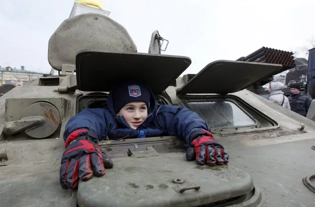 A boy sits inside an armoured personnel carrier (APC) during the opening of an exhibition displaying military weapons and vehicles seized from pro-Russian separatists during fighting in eastern Ukraine, in central Kiev February 21, 2015. The exhibit shows military weapons which are of Russian origin, according to organizer Ukraine's Presidential Administration. REUTERS/Valentyn Ogirenko  (UKRAINE - Tags: CIVIL UNREST MILITARY)