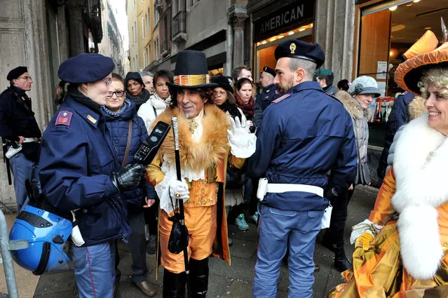 Police officers check a man wearing a carnival costume in Venice, Italy, Sunday, January 31 2016. (Photo by Luigi Costantini/AP Photo)
