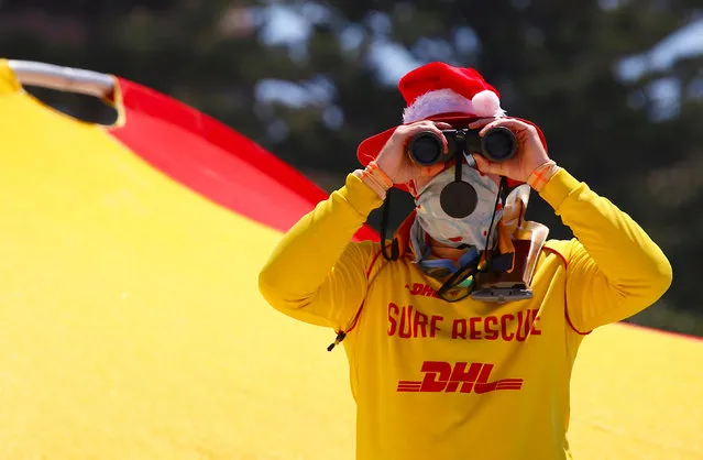 A surf lifesaver looks through binoculars while wearing a Christmas hat on Christmas Day at Sydney's Bondi Beach in Australia, December 25, 2016. (Photo by David Gray/Reuters)