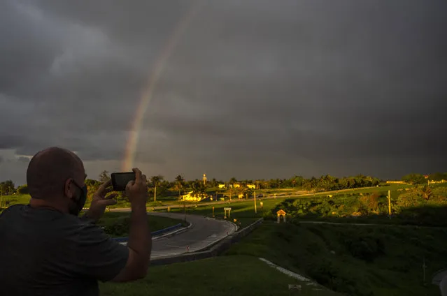 A photographer takes a photo with his cell phone of a rainbow that came out after of the passage of Tropical Storm Elsa, in Havana, Cuba, Monday, July 5, 2021. (Photo by Ramon Espinosa/AP Photo)