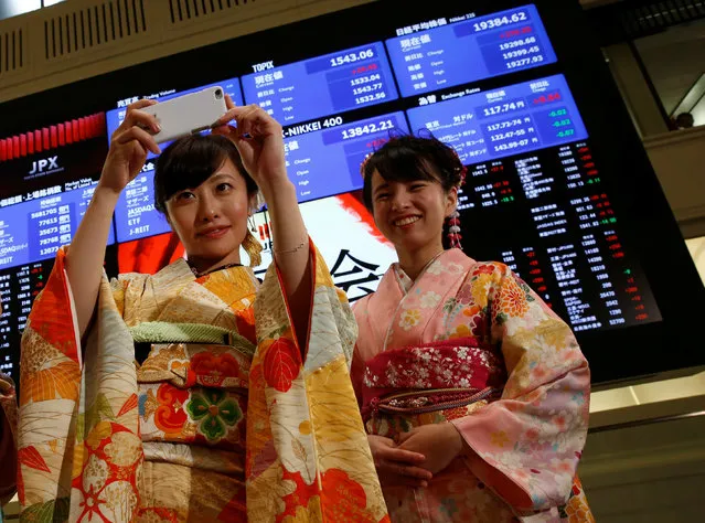 A woman, dressed in ceremonial kimonos, takes a picture in front of an electronic board showing stock prices after  the New Year opening ceremony at the Tokyo Stock Exchange (TSE), held to wish for the success of Japan's stock market, in Tokyo, Japan, January 4, 2017. (Photo by Kim Kyung-Hoon/Reuters)