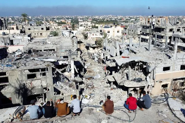 Palestinians look at the houses destroyed in Israeli strikes during the conflict, amid the temporary truce between Israel and the Palestinian Islamist group Hamas, at Khan Younis refugee camp, in the southern Gaza Strip on November 29, 2023. (Photo by Mohammed Salem/Reuters)