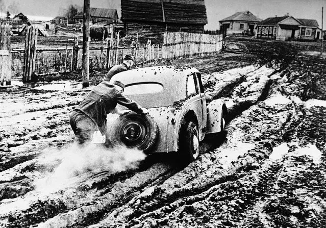 One of the German worker's cars, the Volkswagen, stuck in thick mud and being helped on by Nazi soldiers as it is unable to get on under its own power, somewhere in Russia on December 7, 1941. It also illustrates how this endless boggy mud is now greatly hampering and disorganizing the Nazi retreat. (Photo by AP Photo)