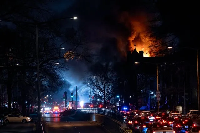 Flames shoot from a two alarm fire, at right, that started in a former fire station, Old Engine Company No. 12, now a landmark along North Capitol Street, in the Bloomingdale neighborhood of Washington, Friday, December 15, 2023. (Phoot by Andrew Harnik/AP Photo)