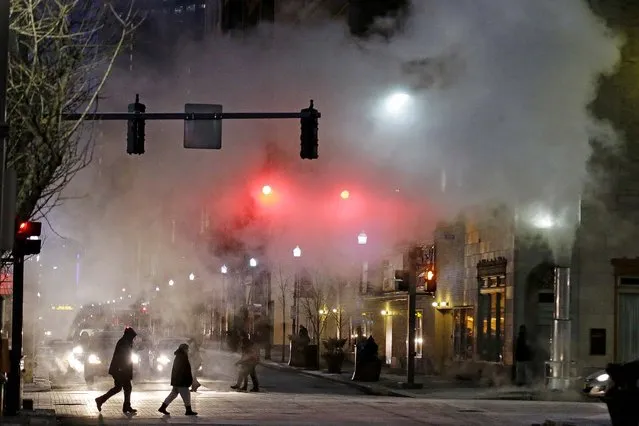 With temperatures nearing zero, a cloud of steam from a manhole blows across an intersection in downtown Pittsburgh during Monday's evening rush hour. The National Weather service is calling for a temperature of -11 degrees overnight, with a high of 2 degrees on Tuesday. (Photo by Gene J. Puskar/Associated Press)