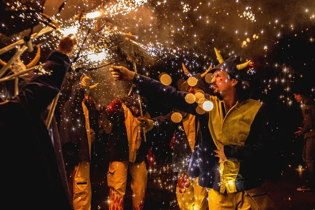 Fire runners of the “Diabolica de Gracia” in devil costumes gather to enlighten their stick mounted firecrackers celebrating their 40th anniversary in Barcelona, Spain on November 19, 2022. (Photo by Matthias Oesterle/EPA/EFE/Rex Features/Shutterstock)
