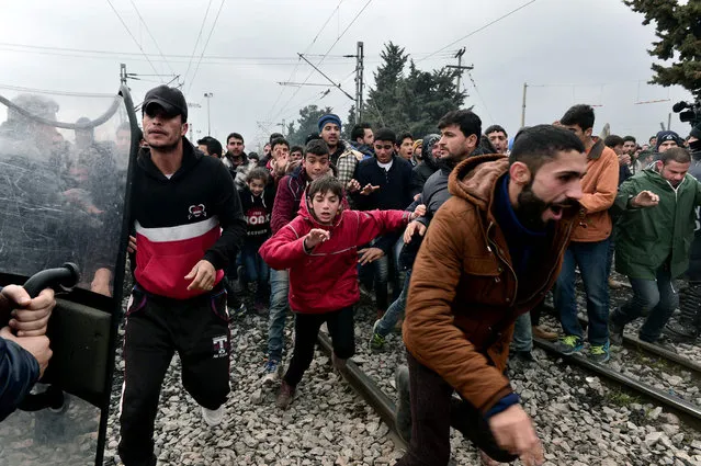 Migrants run after breaking Greek police blockade towards the border fence of Macedonia near the Greek village of Idomeni, on February 29, 2016. (Photo by Louisa Gouliamaki/AFP Photo)