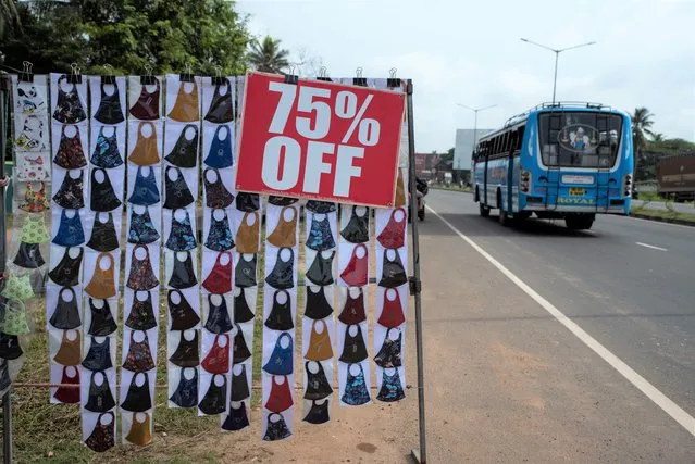 Face masks are displayed for sale by the side of a highway in Kochi, Kerala state, India, Monday, September 20, 2021. The tiny southern state continues to battle the highest number of coronavirus cases in the country. (Photo by R.S. Iyer/AP Photo)