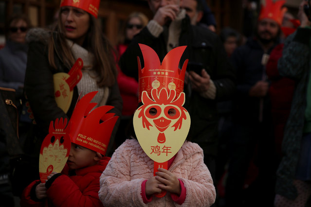 A girl wears a mask reading “Year of the rooster” as she watches a parade to celebrate the Chinese Lunar New Year of the Rooster in Madrid, Spain, January 28, 2017. (Photo by Susana Vera/Reuters)