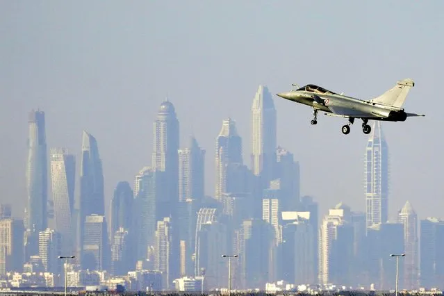 The skyline of the city is seen on the background as a French Air Force Dassault Rafale C jet fighter prepares to land during the opening day of the Dubai Air Show, United Arab Emirates, Monday, November 13, 2023. (Photo by Kamran Jebreili/AP Photo)