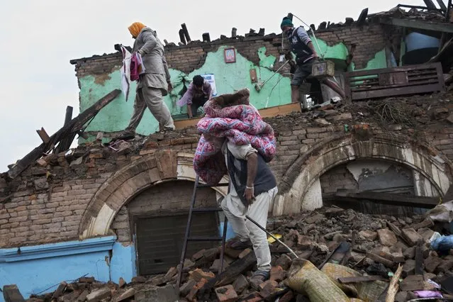 Residents rescue items from debris of a house that was damaged in Saturday's earthquake in Kathmandu, Nepal, Monday, April 27, 2015. (Photo by Bernat Armangue/AP Photo)