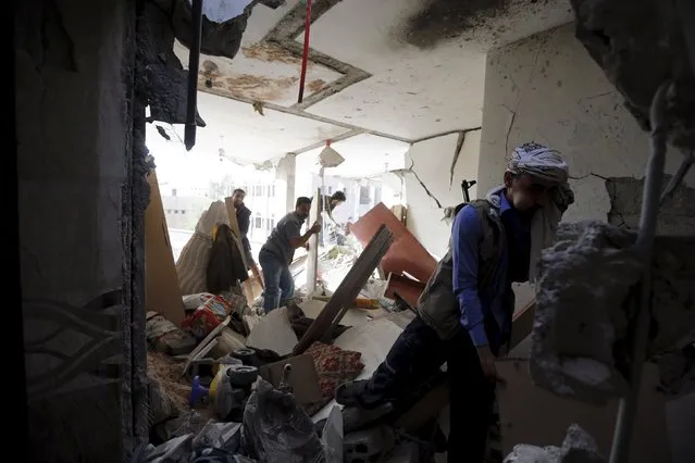 People salvage furniture from the rubble of a house destroyed by an air strike on houses in Sanaa April 26, 2015. (Photo by Khaled Abdullah/Reuters)