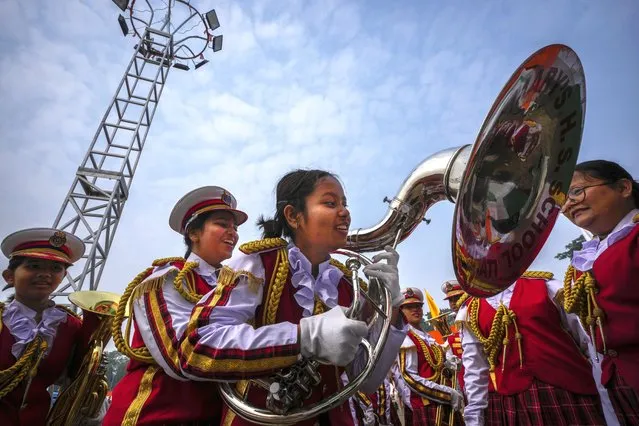 A school student helps another to hold a musical instrument before participate in the Republic Day parade in Guwahati, India, Friday, January 26, 2024. (Photo by Anupam Nath/AP Photo)