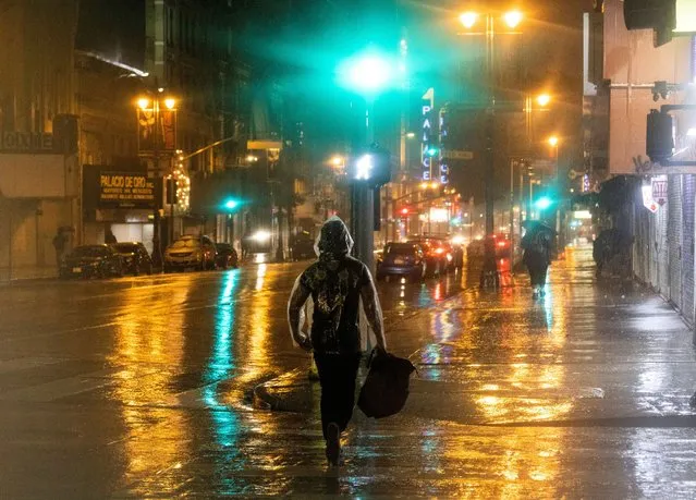 People walk downtown during heavy rains in Los Angeles, February 4, 2024. (Photo by Aude Guerrucci/Reuters)