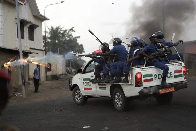 Burundi riot police fire tear gas as they chase demonstrators during clashes in Bujumbura, Burundi, Wednesday April 29, 2015. Protesters were again on the streets Wednesday, angry over the Burundian president's third term bid that they say is unconstitutional as a top U.S. diplomat headed to the East African nation. (Photo by Jerome Delay/AP Photo)