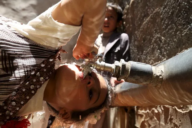 A girl drinks water from a faucet amid an acute shortage of clean drinking water in Sanaa, April 24, 2015. (Photo by Mohamed al-Sayaghi/Reuters)