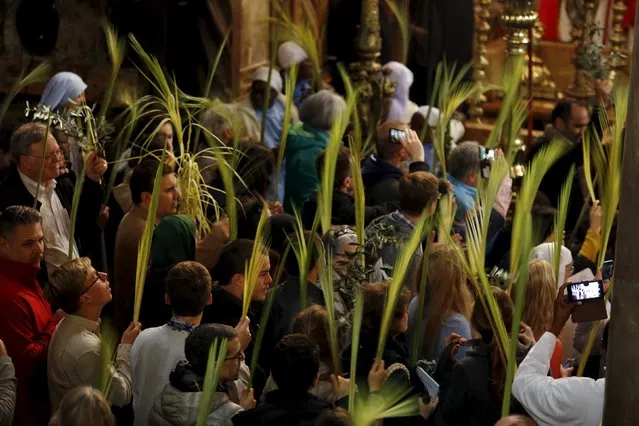 Worshippers hold palm fronds as they take part in a Palm Sunday procession at the Church of the Holy Sepulchre in Jerusalem's Old City March 20, 2016. (Photo by Amir Cohen/Reuters)