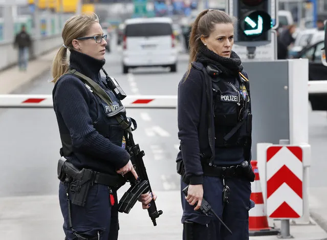 German police officers guard the driveway to the airport in Frankfurt, Germany, during tighter security measures Tuesday, March 22, 2016, when various explosions hit the the Belgian capital Brussels killing several people. (Photo by Michael Probst/AP Photo)