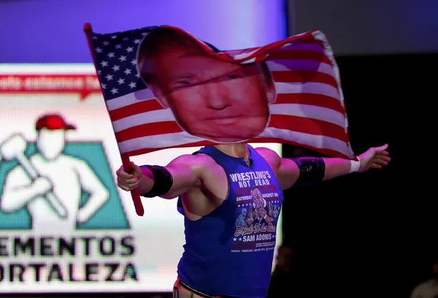 Wrestler Sam Polinsky aka Sam Adonis takes the ring at Arena Mexico waving an American flag emblazoned with a photo of U.S. President Donald Trump, in Mexico City, Sunday, February 12, 2017. He's the guy Mexicans love to hate: The American pro wrestler has become a sensation in Mexico City by adopting the ring persona of a flamboyant Trump supporter. (Photo by Eduardo Verdugo/AP Photo)
