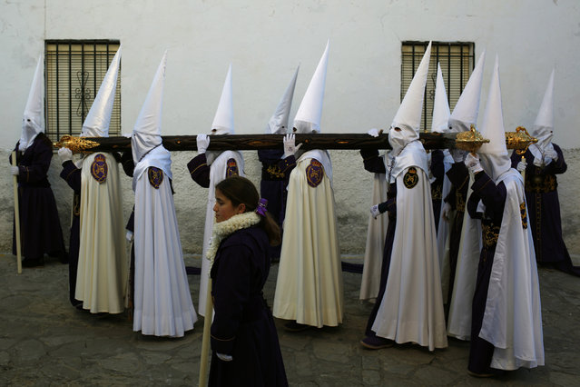 Penitents of the Cautivo brotherhood carry a cross as they take part in a procession at dawn during Holy Week in Arriate, near Malaga, southern Spain, March 24, 2016. (Photo by Jon Nazca/Reuters)