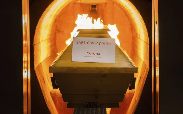 A coffin labelled with a paper 'SARS-CoV-2 positive - Corona' cremated in the crematorium in Giesen, Germany, November 25, 2021. Germany’s disease control agency said it recorded 351 additional deaths in connection with the coronavirus over the past 24 hours, taking the total toll to 100,119. In Europe, Germany is the fifth country to pass that mark, after Russia, the United Kingdom, Italy and France. (Photo by Julian Stratenschulte/dpa via AP Photo)